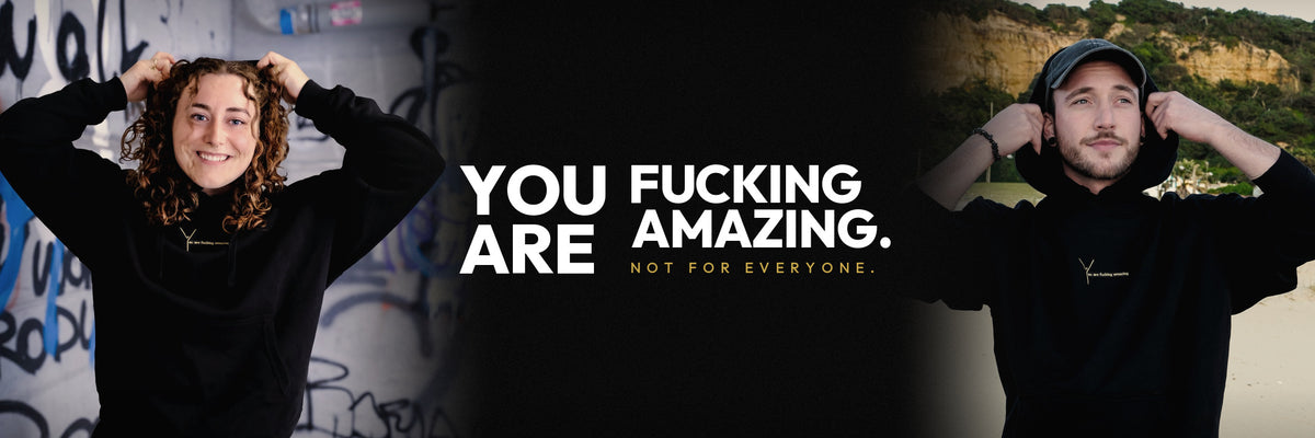 Eine Frau und ein Mann in schwarzen YAFATAR Hoodies ziehen sich die Kapuze über. Schriftzug: You are fucking amazing. Not for everyone.